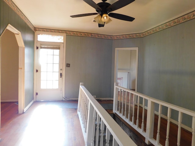 corridor featuring baseboards, an upstairs landing, and wood finished floors