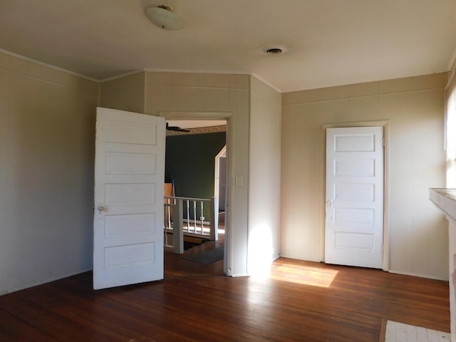 spare room with visible vents, wood finished floors, and ornamental molding