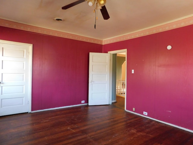 unfurnished bedroom featuring a ceiling fan, crown molding, wood finished floors, and visible vents