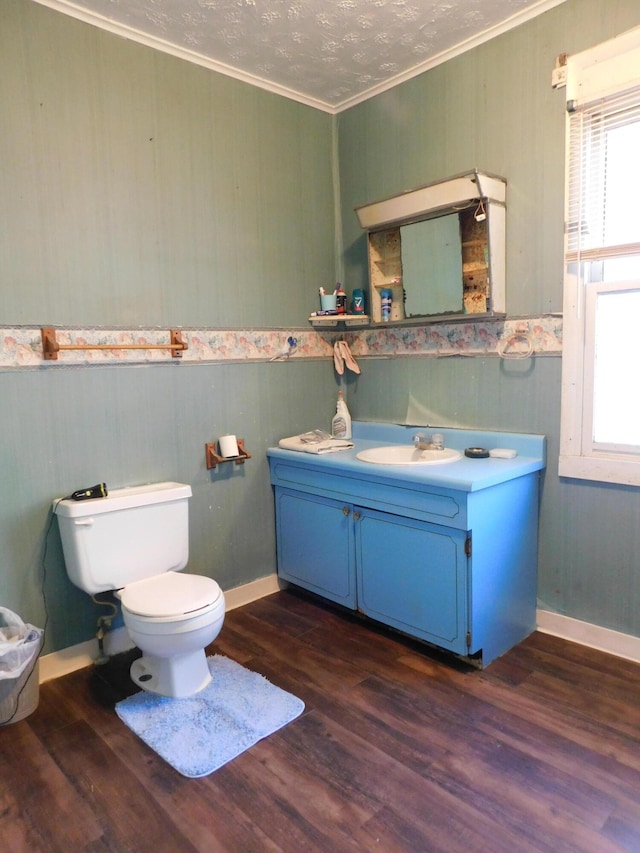 bathroom with a healthy amount of sunlight, wood finished floors, and ornamental molding