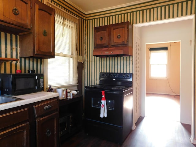 kitchen featuring wallpapered walls, black appliances, light countertops, and under cabinet range hood