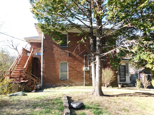 view of side of property featuring stairway and brick siding