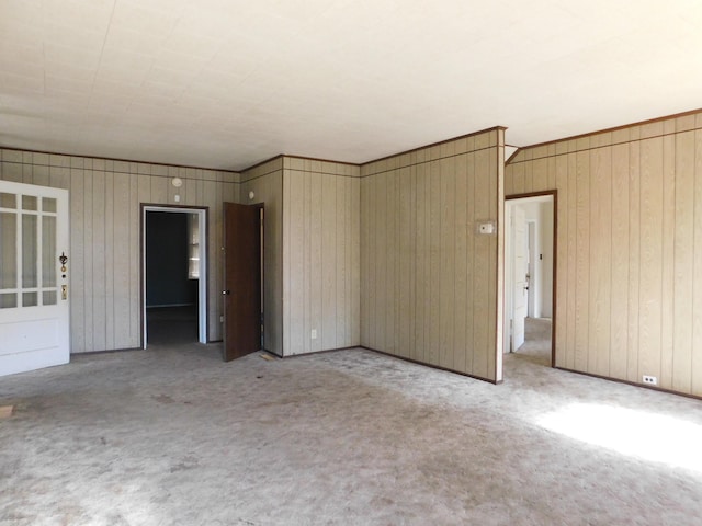 empty room with wood walls and carpet floors