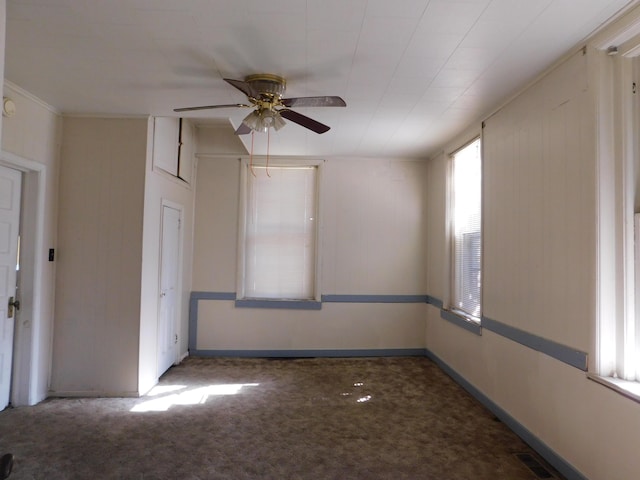 unfurnished room with visible vents, carpet flooring, a ceiling fan, and baseboards