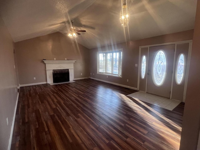 entryway with a fireplace with flush hearth, lofted ceiling, a ceiling fan, dark wood-style floors, and baseboards