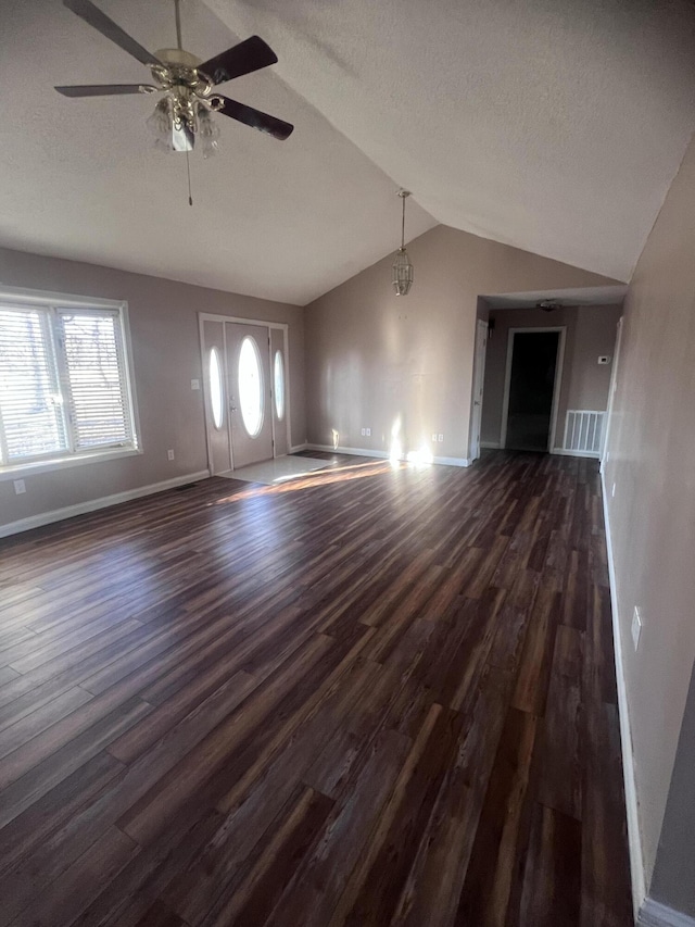 unfurnished living room featuring lofted ceiling, a textured ceiling, and dark wood-type flooring