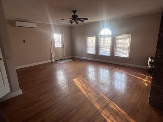 unfurnished living room with crown molding, ceiling fan, baseboards, an AC wall unit, and wood finished floors