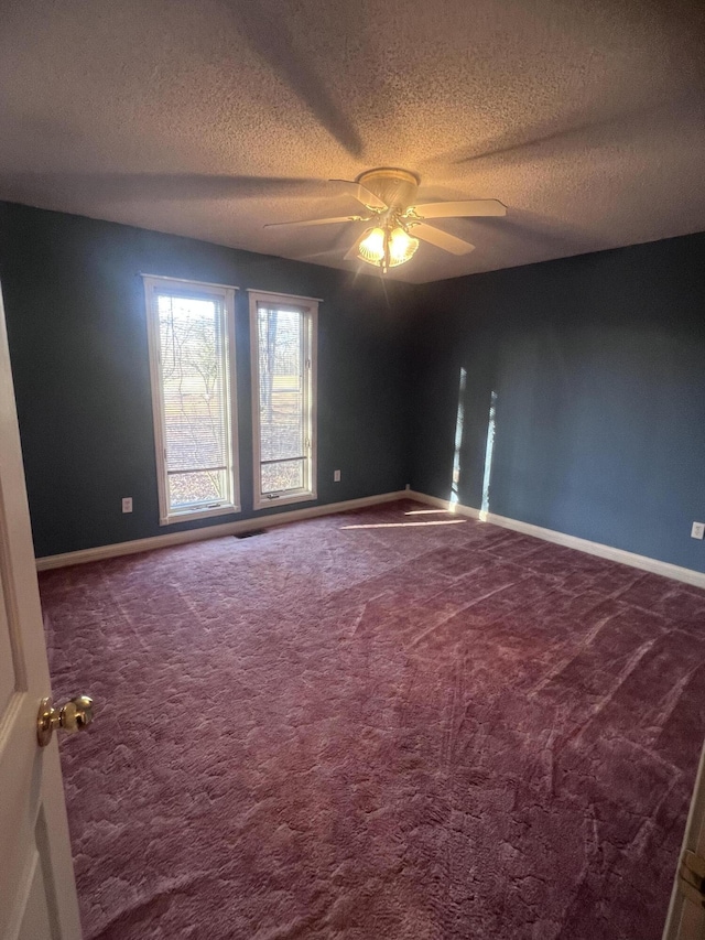 unfurnished room featuring baseboards, carpet, a ceiling fan, and a textured ceiling