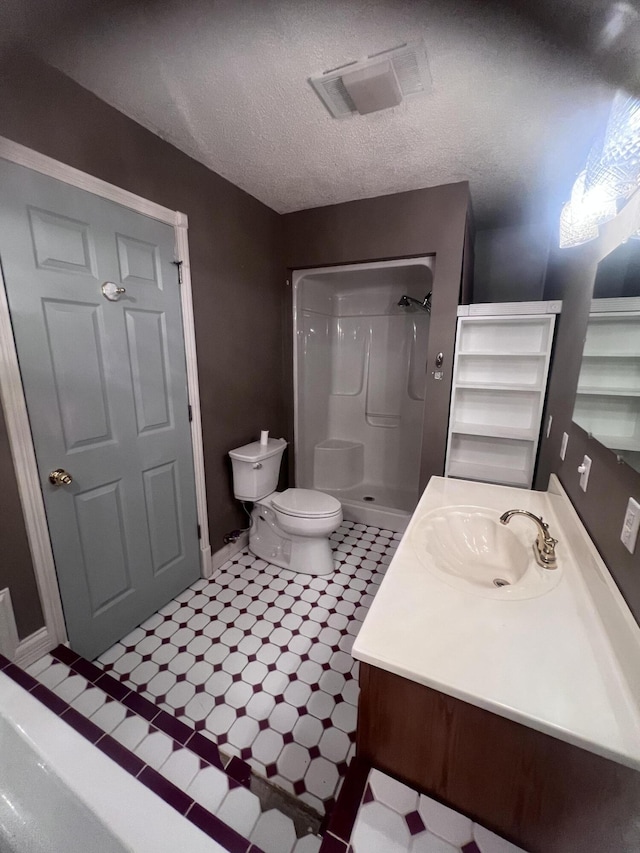 bathroom featuring vanity, walk in shower, a textured ceiling, tile patterned floors, and toilet