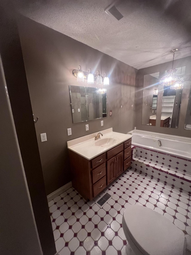 bathroom featuring vanity, visible vents, a textured ceiling, tile patterned floors, and toilet