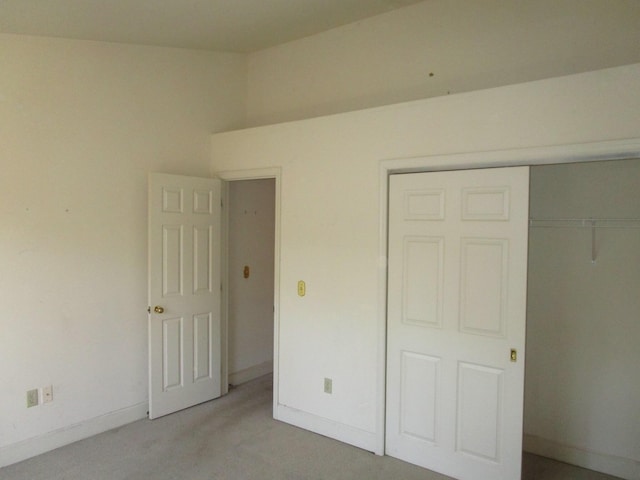 unfurnished bedroom with a closet, baseboards, and light colored carpet