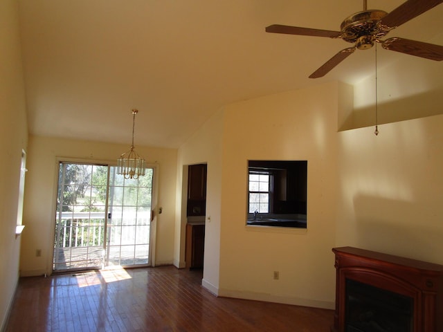 unfurnished living room featuring a healthy amount of sunlight, baseboards, lofted ceiling, and wood finished floors