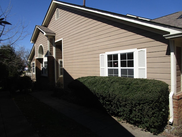 view of side of property with a shingled roof