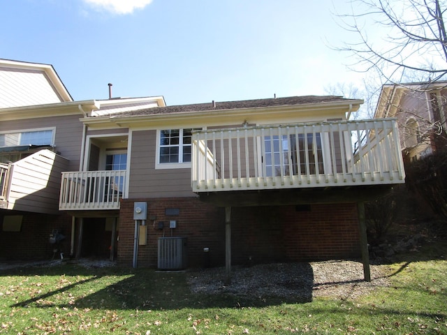 back of property with brick siding, central AC unit, a lawn, and a deck