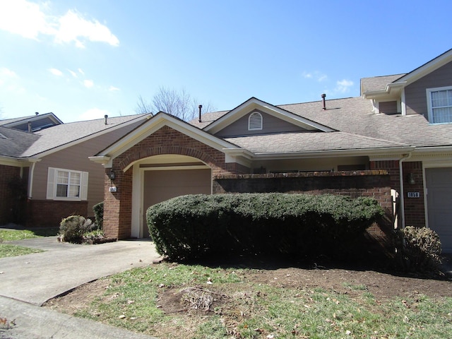 view of front of property featuring a garage, brick siding, roof with shingles, and driveway