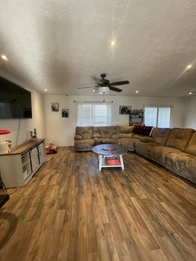 unfurnished living room with a textured ceiling, a healthy amount of sunlight, and wood finished floors