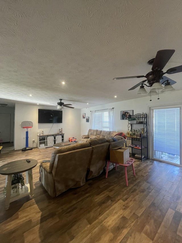 living room with a textured ceiling, wood finished floors, and ceiling fan