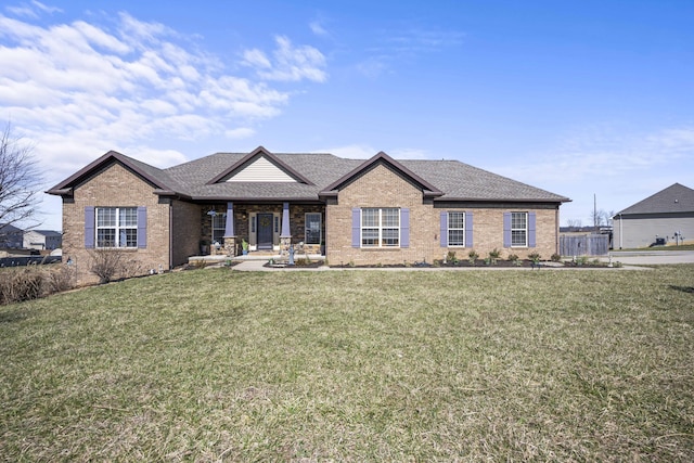 view of front facade featuring brick siding, a shingled roof, and a front lawn