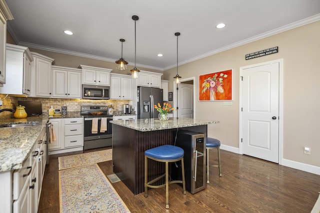 kitchen with a sink, crown molding, and stainless steel appliances