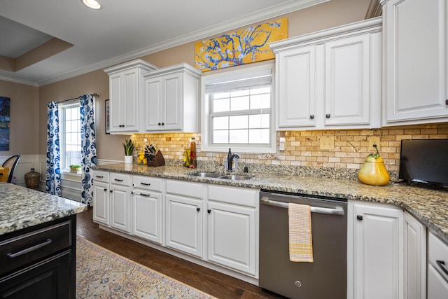 kitchen with dark wood finished floors, a sink, crown molding, and stainless steel dishwasher