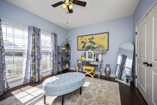 sitting room with arched walkways, a healthy amount of sunlight, baseboards, and wood finished floors