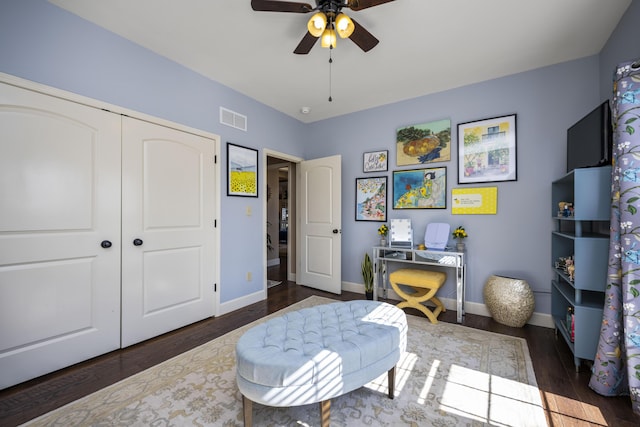 office area with ceiling fan, wood finished floors, visible vents, and baseboards