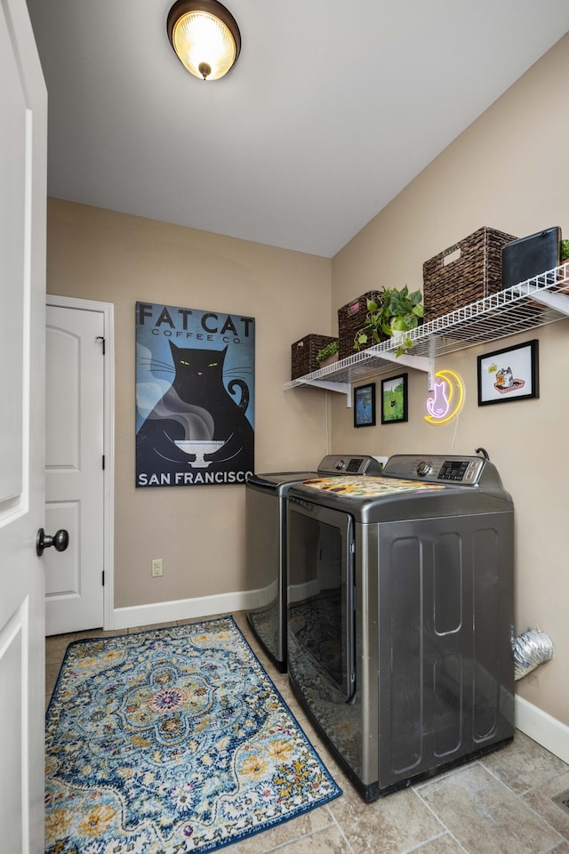 laundry room with baseboards, separate washer and dryer, and laundry area