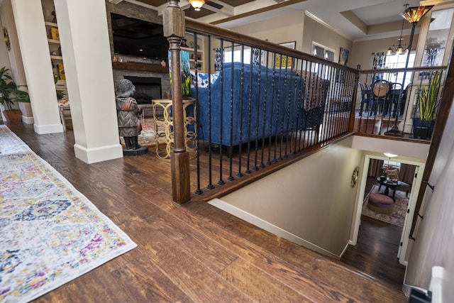 stairs with ornamental molding, hardwood / wood-style floors, a high ceiling, a fireplace, and baseboards