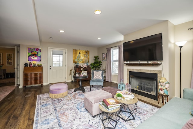 living room featuring a tiled fireplace, recessed lighting, baseboards, and wood finished floors