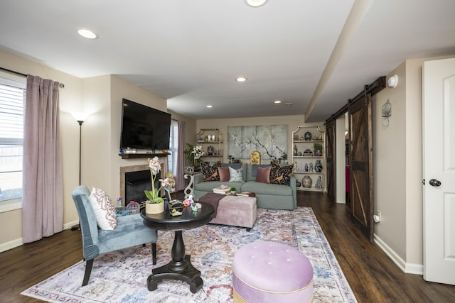 living area featuring recessed lighting, a barn door, wood finished floors, and a tile fireplace