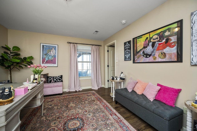 living room featuring wood finished floors, visible vents, and baseboards