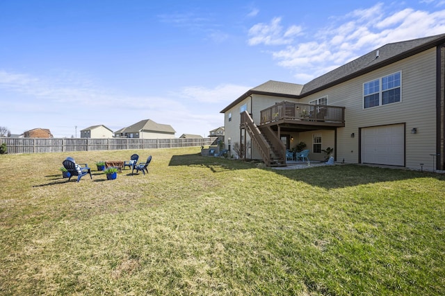 view of yard with a fire pit, fence, stairway, a garage, and a deck