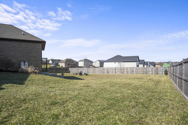 view of yard with a fenced backyard and a residential view