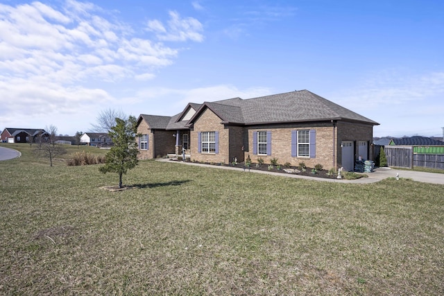 view of front of property with a front lawn, driveway, fence, a garage, and brick siding