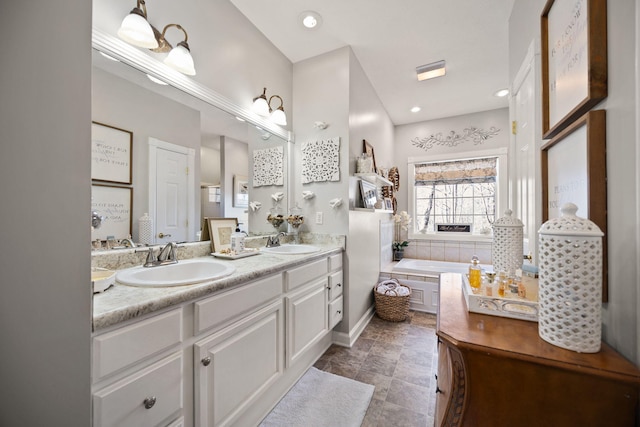 full bath with a sink, recessed lighting, a bath, and double vanity