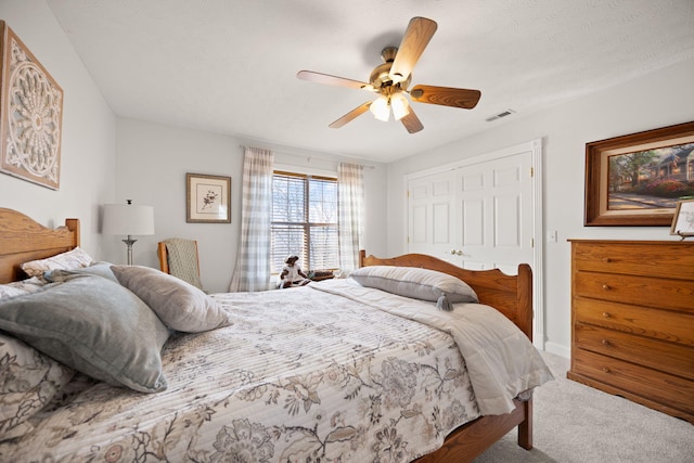 carpeted bedroom featuring visible vents, a closet, and ceiling fan