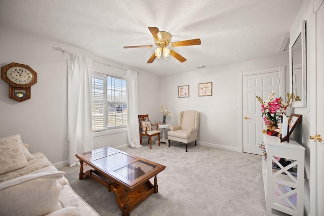 living area with ceiling fan, baseboards, and light carpet