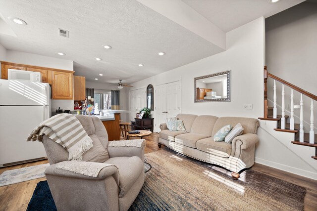 living area with visible vents, recessed lighting, stairway, and wood finished floors