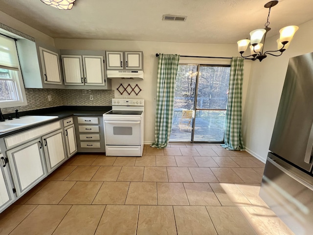 kitchen featuring visible vents, a sink, under cabinet range hood, dark countertops, and white electric range oven