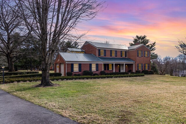 2136 Adena Ln, Lexington, KY 40516 - traditional home featuring a front lawn, metal roof, brick siding, and a chimney