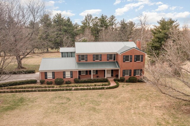 2136 Adena Ln, Lexington, KY 40516 - view of front facade with a standing seam roof, a chimney, a front lawn, brick siding, and metal roof