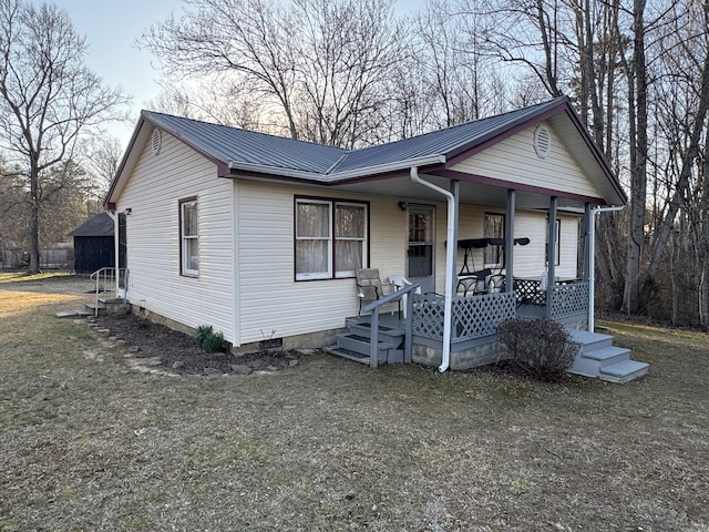 view of front facade with crawl space, metal roof, and covered porch