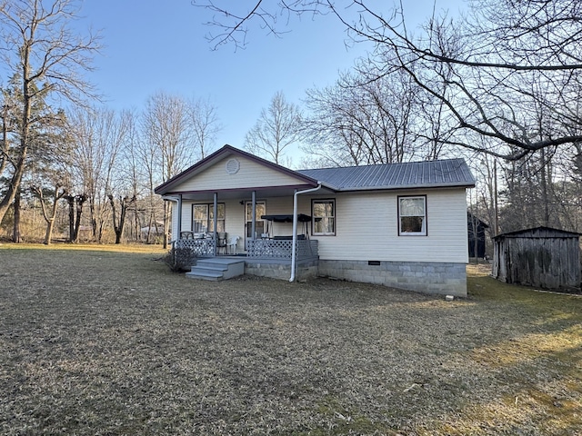 view of front facade with an outbuilding, a shed, a porch, crawl space, and metal roof