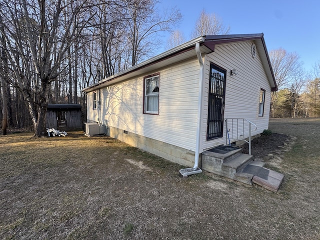 view of home's exterior with crawl space and central AC unit