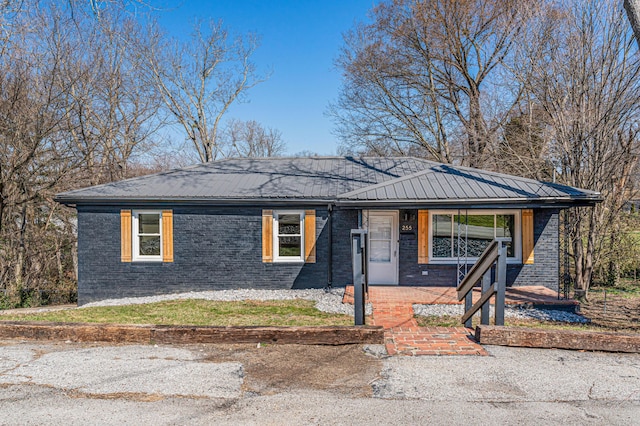 single story home with brick siding and metal roof