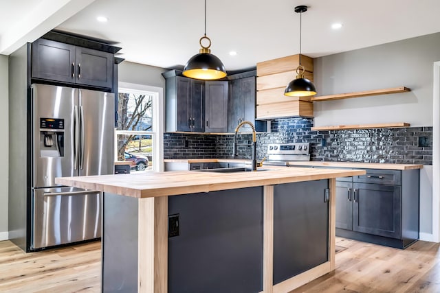 kitchen featuring decorative backsplash, light wood-style floors, stainless steel appliances, wood counters, and a sink