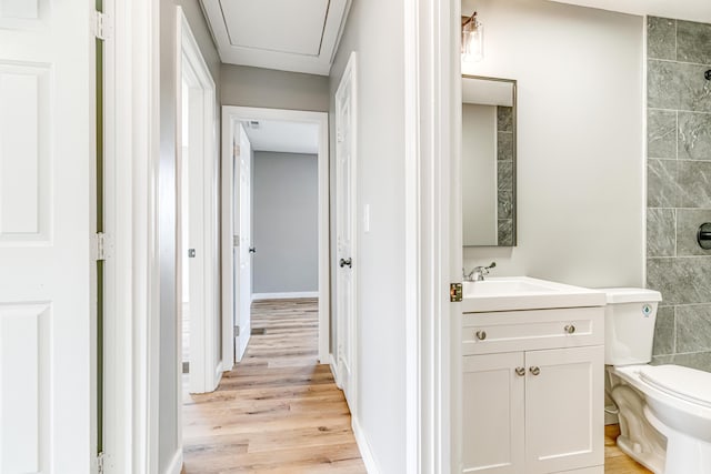 full bathroom featuring tiled shower, toilet, wood finished floors, and vanity