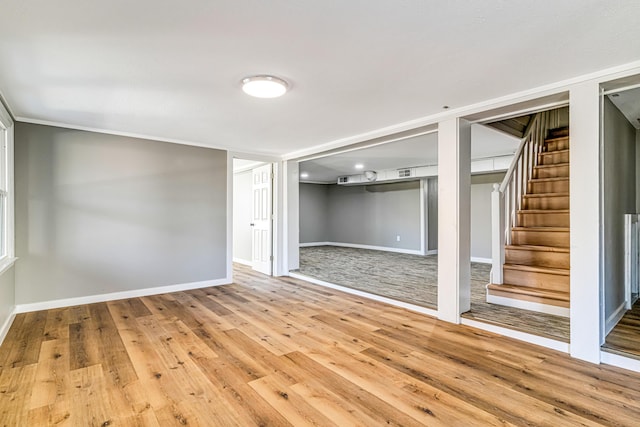 spare room with stairs, baseboards, and wood finished floors