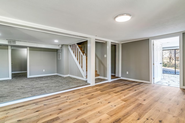 basement with stairs, hardwood / wood-style flooring, baseboards, and visible vents