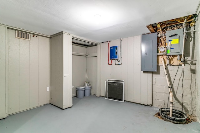 unfinished basement featuring electric panel and visible vents